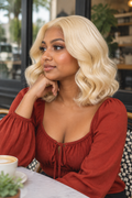  Front portrait view of a short twelve inch sixty one three platinum blonde body wave human hair bob wig with a deep center part by The PM Edit.