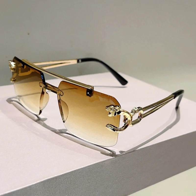 Gold-framed sunglasses with gradient lenses on a light surface