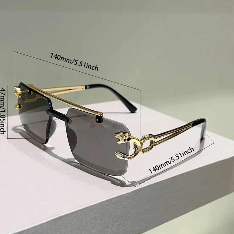 Gold and black rimless sunglasses with measurements on a light gray background