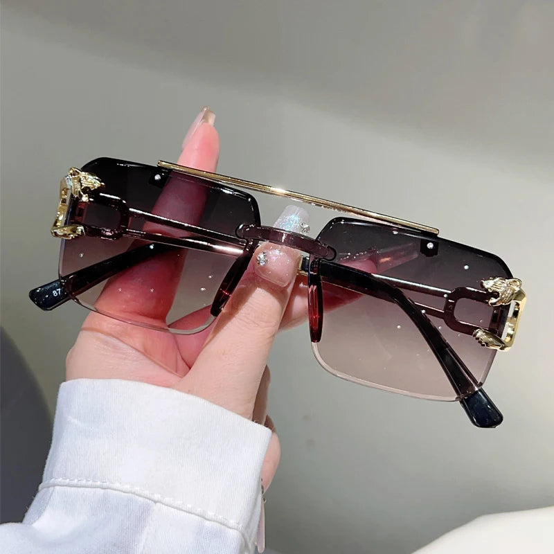 Sunglasses with decorative elements held by a hand against a neutral background