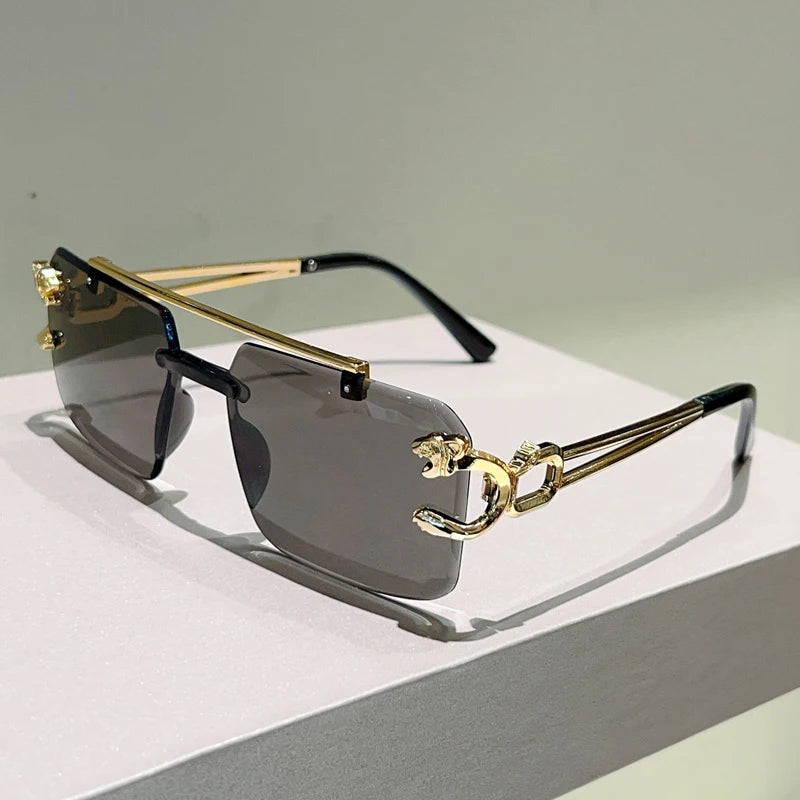 Sunglasses with gold and black frame on a light surface