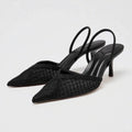 Black woven high-heeled shoes on a light gray background