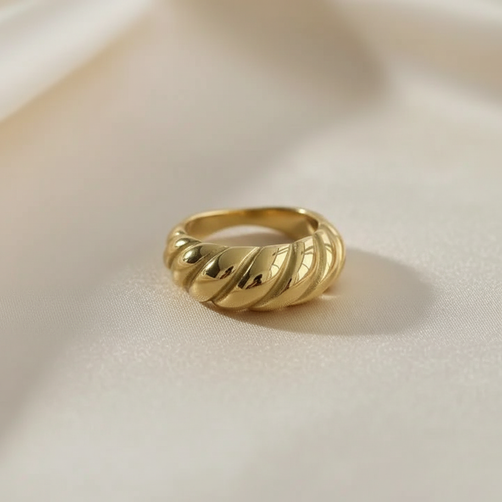 Close studio product image of an 18K gold PVD croissant twisted dome ring shown alone