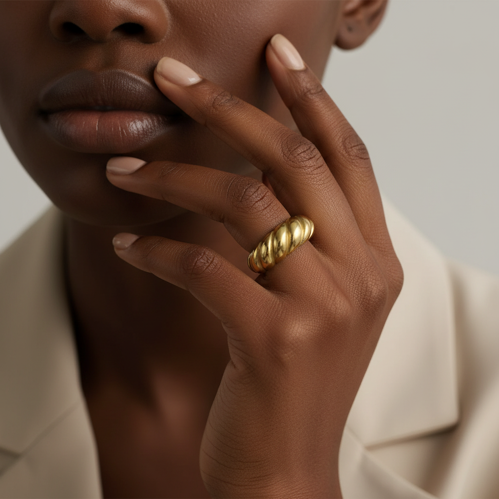 18K gold PVD croissant twisted dome ring worn on a model's hand in a close-up lifestyle image