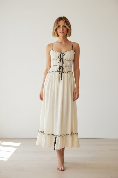 Model wearing the white frill tied-front midi cami dress in a studio