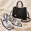 Front portrait shot of the luxury holiday gift capsule displaying a handmade leather saddle bag gold dome hoops and a folded nautical silk scarf by The PM Edit.