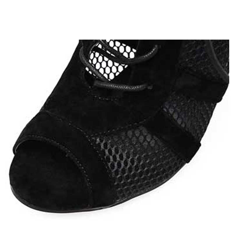 Close up of black cross-tied stiletto ankle boots with mesh fabric and open toe detailing by The PM Edit.